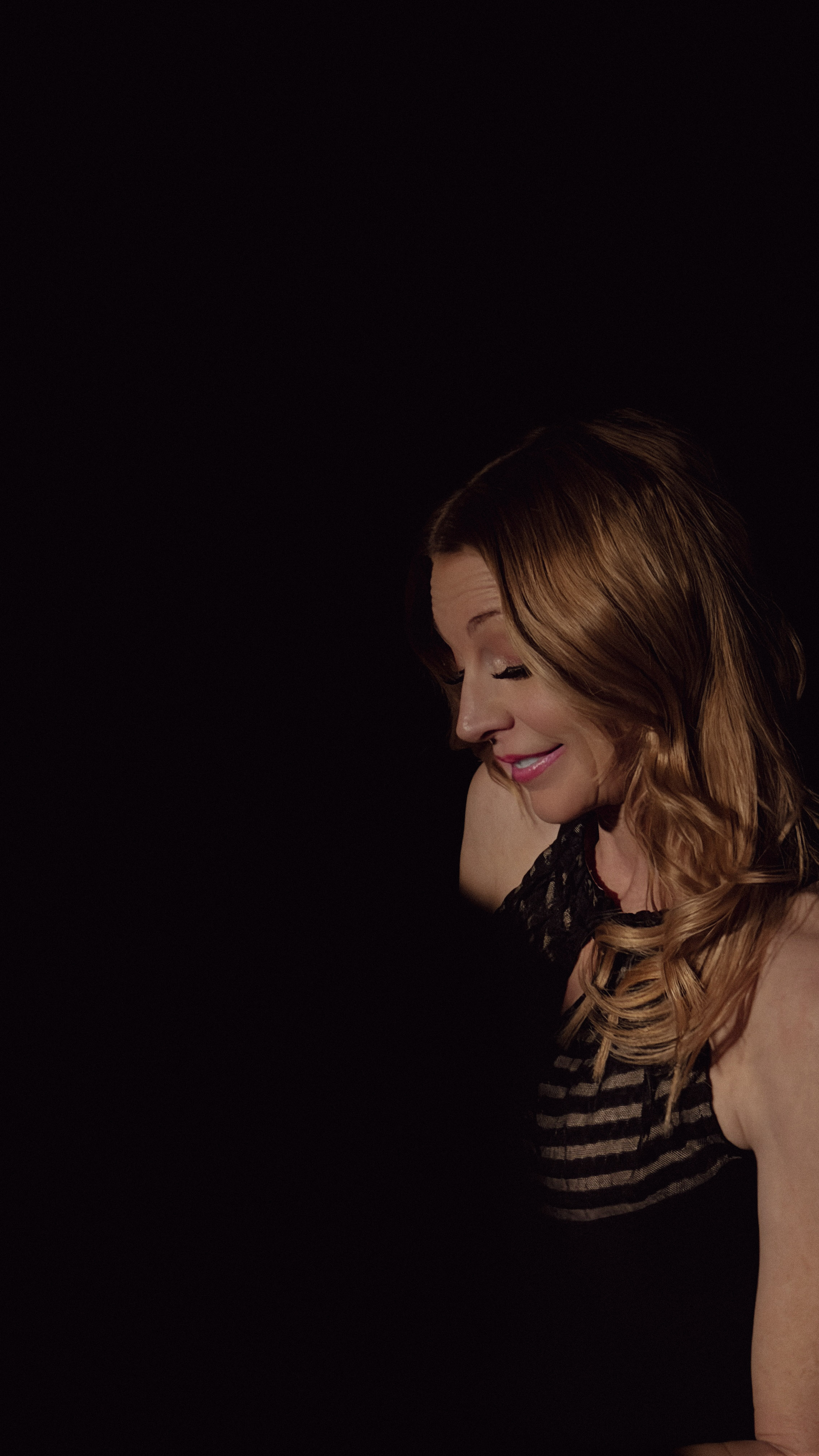 Lisa Apple — side profile in warm amber light at the piano